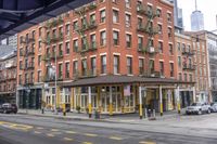 an old red brick building is on the corner of the street, with some yellow trims