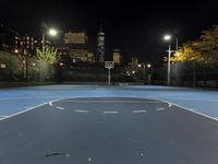 a basketball court with a city in the background at night time, with a half moon behind it