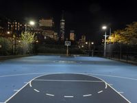 a basketball court with a city in the background at night time, with a half moon behind it
