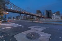 an empty road on a city street near the water at night, with streetlights glowing down