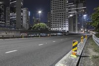 a city street at night with traffic cones and skyscrapers in the background in new york, ny