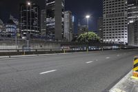 a city street at night with traffic cones and skyscrapers in the background in new york, ny