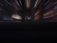 an abstract photo taken at night showing some buildings in the background and lights in the distance