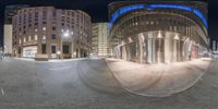 a round mirror reflecting the exterior of a large building at night, with its reflection in the corner