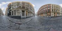 two identical pictures of a street with buildings on it's sides and cobblestones on the pavement below