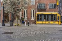 a yellow restaurant with a awning on the sidewalk in front of it and a building behind it