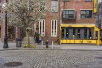 a yellow restaurant with a awning on the sidewalk in front of it and a building behind it