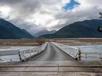 the view of mountains on the mountain range from a bridge at a train station in new zealand