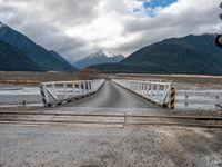 the view of mountains on the mountain range from a bridge at a train station in new zealand