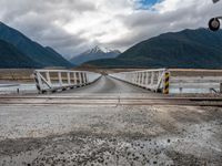 the view of mountains on the mountain range from a bridge at a train station in new zealand