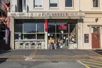 a small grocery store on the corner of a street between two tall buildings in front