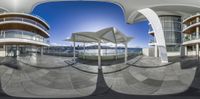 a fish eye view of a city skyline with umbrellas and balconves around