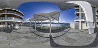 a fisheye view of several buildings in a city by the ocean from this perspective