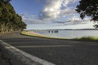 a curved road passes the water towards some land to a bridge and a body of water