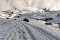 a lone snow skier making his way up a snowy mountain slope with large rocks in the distance