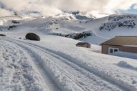 a lone snow skier making his way up a snowy mountain slope with large rocks in the distance