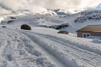 a lone snow skier making his way up a snowy mountain slope with large rocks in the distance