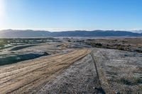 a rural road curves through the middle of a barren landscape, on a sunny day