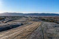 a rural road curves through the middle of a barren landscape, on a sunny day