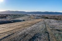 a rural road curves through the middle of a barren landscape, on a sunny day