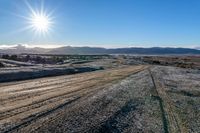 a rural road curves through the middle of a barren landscape, on a sunny day