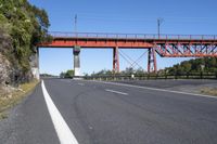 a large bridge on top of an orange bridge over a highway in the middle of nowhere