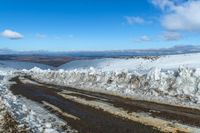 a snowy road with snow on the ground and mountains in the background behind it for a short time