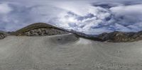 a very wide and long panorama shot of some mountain peaks and clouds in the blue sky