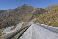 yellow sign on road that says a curve to go ahead on it in mountainous area