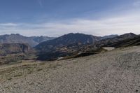 a desert area with rocks and a bike in the middle with mountains in the background