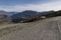 a desert area with rocks and a bike in the middle with mountains in the background