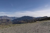 a desert area with rocks and a bike in the middle with mountains in the background