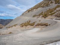 the winding road on the hill is made up by a stone wall and snow in a mountainous area