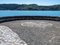 there is an outside area with a stone wall and a large hill on the side