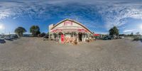 a fisheye view of a restaurant and parked cars in a parking lot in a sunny day