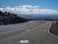 the yellow lines of the road are marking the route to the top of the mountain