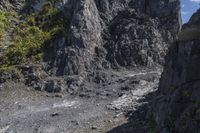 a small mountain is shown with a man walking by it and the top half has mossy rocks