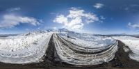 a photo taken from the inside of a panoramic photo of a snow covered road