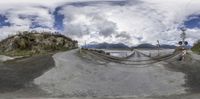 a fisheye lens is seen of the road in the mountains that are reflected in it