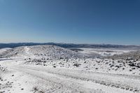 an over the shoulder view of snow covered mountains with rock, rock and snow piled on top