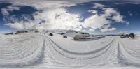 the view through a fish eye lens on a snowy field, with ski tracks in the foreground