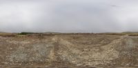 a view out of the back window of a truck traveling down a dirt road next to large rocks