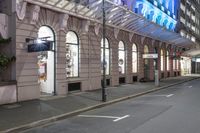 the corner of an empty building has windows lit with brightly lit lights on it's side