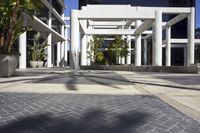 an empty courtyard with a couple of buildings in the background and a planter on the side