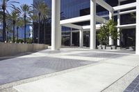 a white and black sign outside of a tall building in california with some palm trees