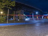 a bridge over a street filled with traffic at night time of some sort, near by