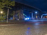 a bridge over a street filled with traffic at night time of some sort, near by