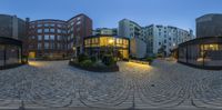 a 360 - view image of a building with a circular courtyard outside it is illuminated at night