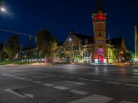 a night scene with traffic lights shining at an intersection with a church in the background