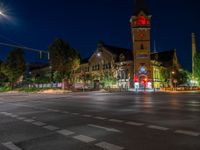 a night scene with traffic lights shining at an intersection with a church in the background